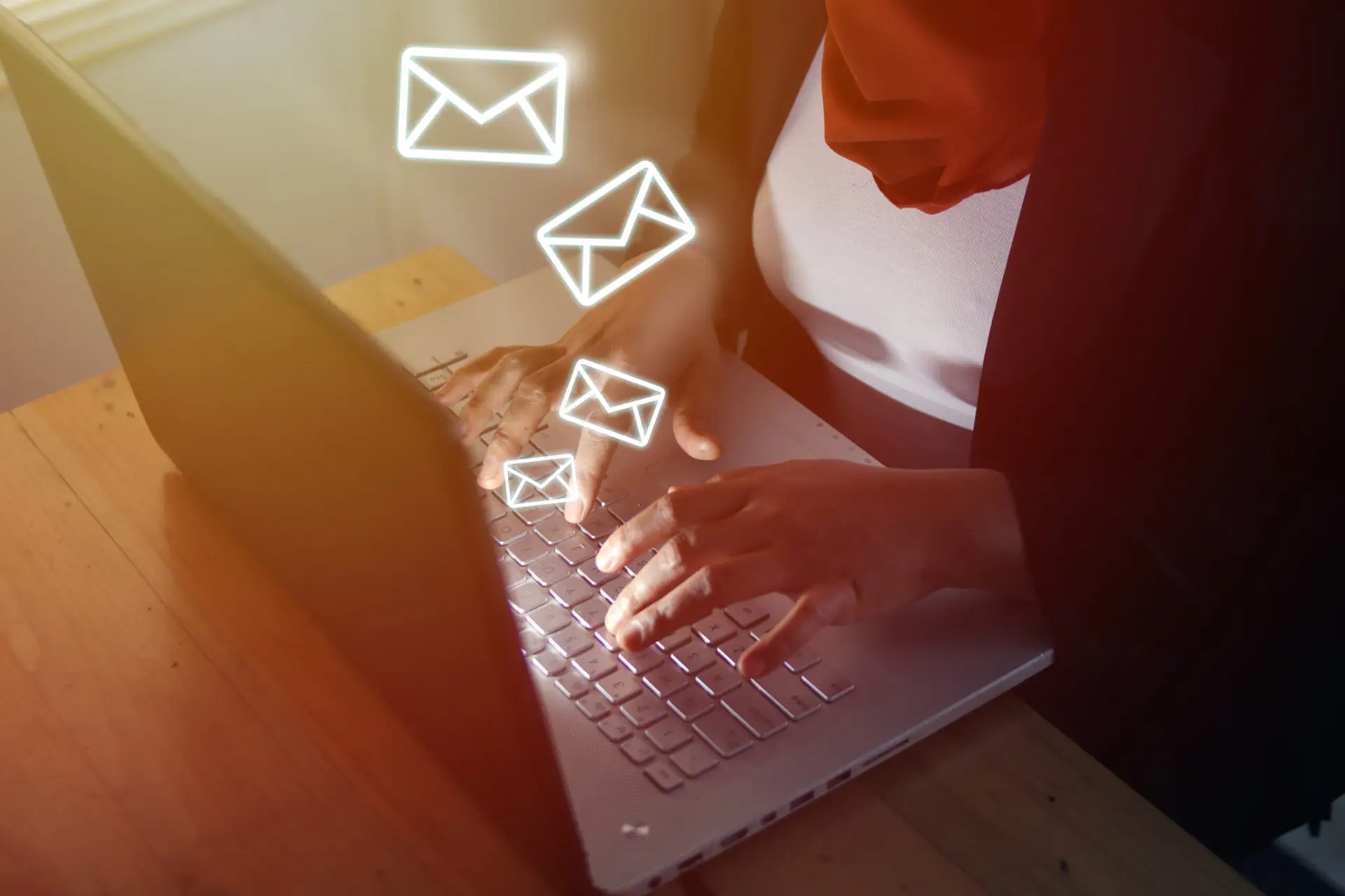 Muslim woman typing on laptop at office with email icons being sent out. Communication business technology. Close up image with selective focus